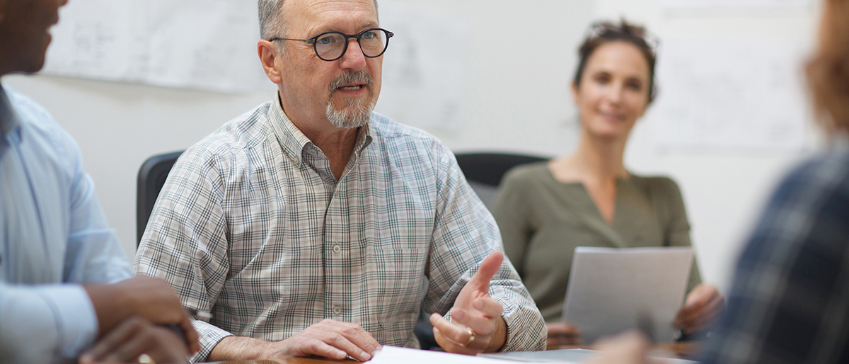 Ein Experte mittleren Alters erklärt etwas in einem Meeting